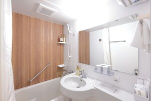 Un baño moderno con tocador de madera, un lavabo blanco y un espejo grande.