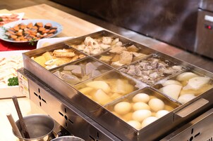 A buffet with various dishes including tofu, meat, and vegetables.