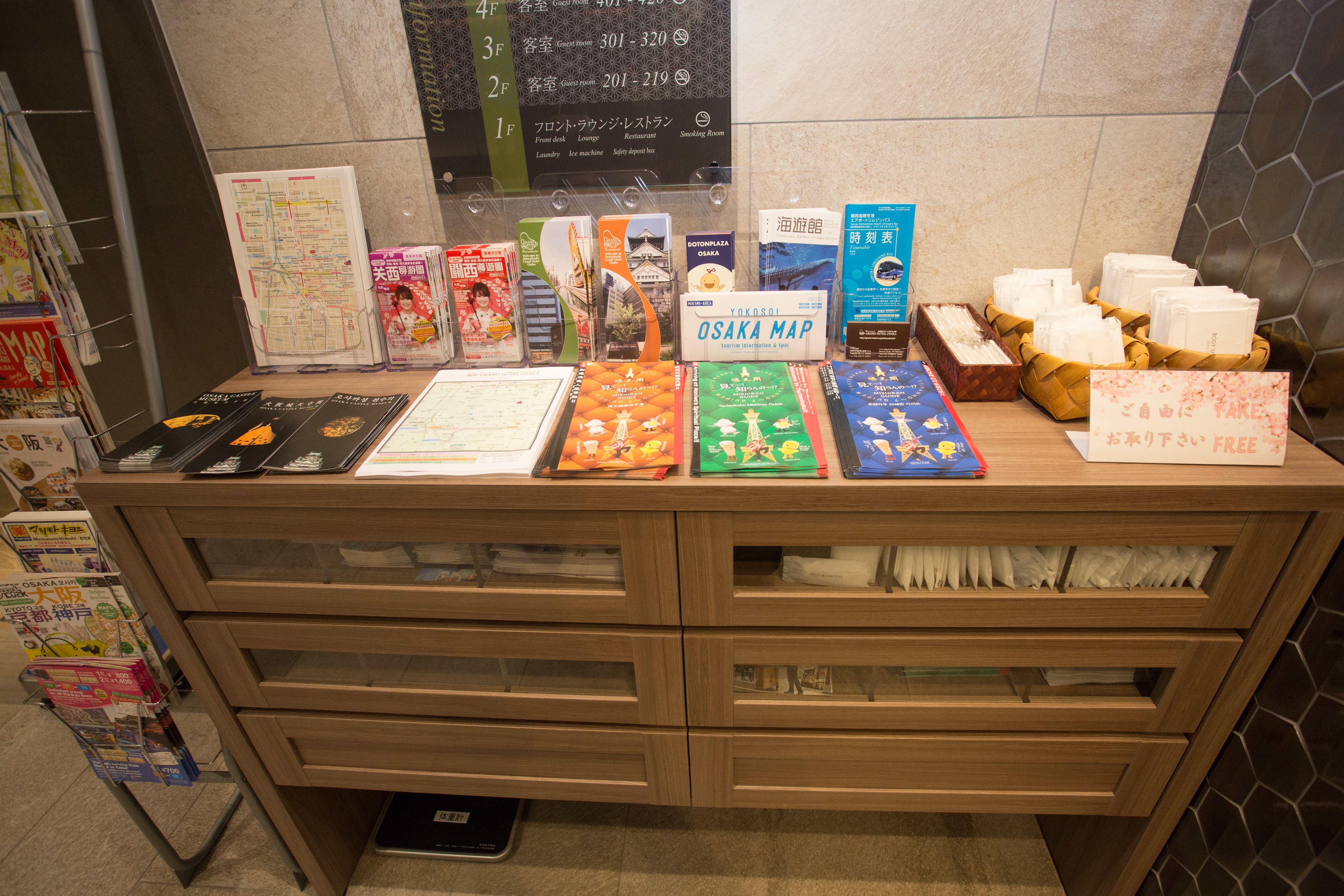 A display of travel books and maps at a hotel reception desk.