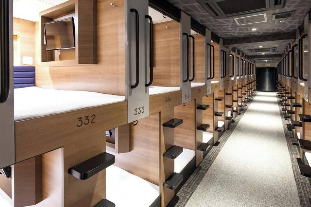 A train carriage with wooden partitions, numbered beds, and a central aisle.