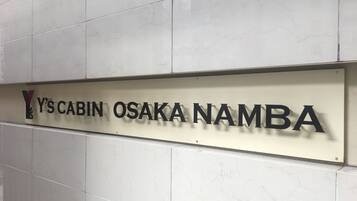 A sign with the text "Y's Cabin Osaka Namba".