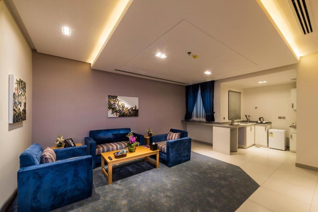 A modern living room with a sofa set, a coffee table, and artwork on the walls.