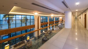 A spacious hotel lobby with a glass floor, seating area, and large windows overlooking the beach. - Boudl Al Munsiyah (Riyadh)