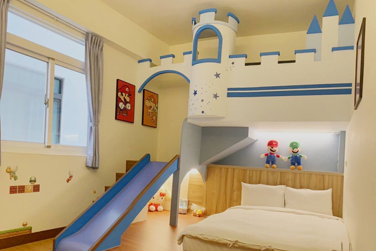 A child's bedroom with a bunk bed, a slide, and playful wall decorations.