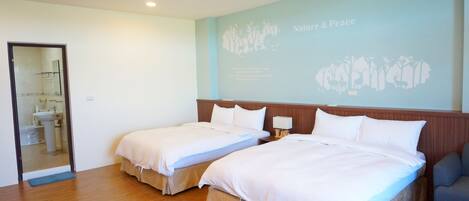 A hotel room with two beds, a wooden floor, a mirror, and a wall with a nature and peace mural.