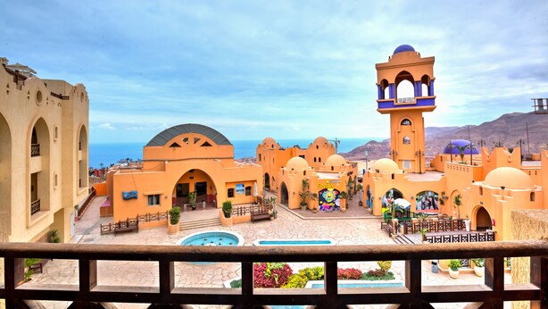 Un resort con piscina, varias edificaciones y una torre de campanas.