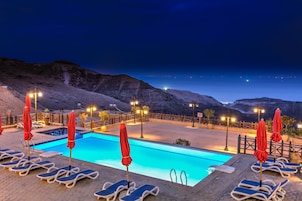 Una piscina al aire libre, sillones reclinables de piscina