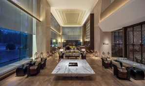 A spacious lobby with a central seating area, a bar, and a view of the outdoors. - Regent Chongqing (Chongqing)
