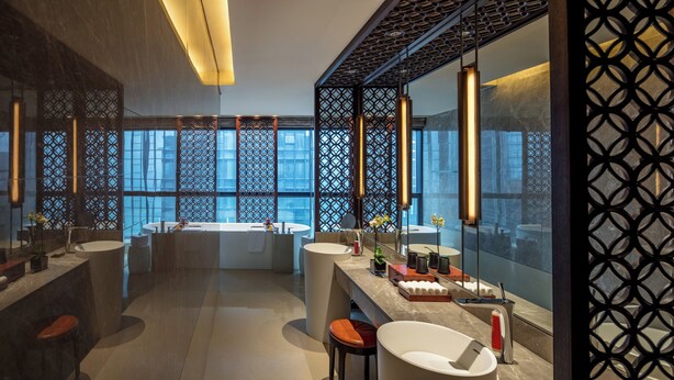 A modern bathroom with a large bathtub, two sinks, and a vanity area. - Regent Chongqing (Chongqing)