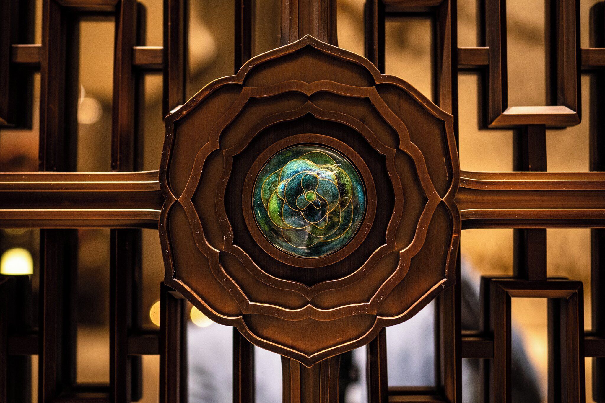 A decorative wooden gate with a circular design and a central emblem.