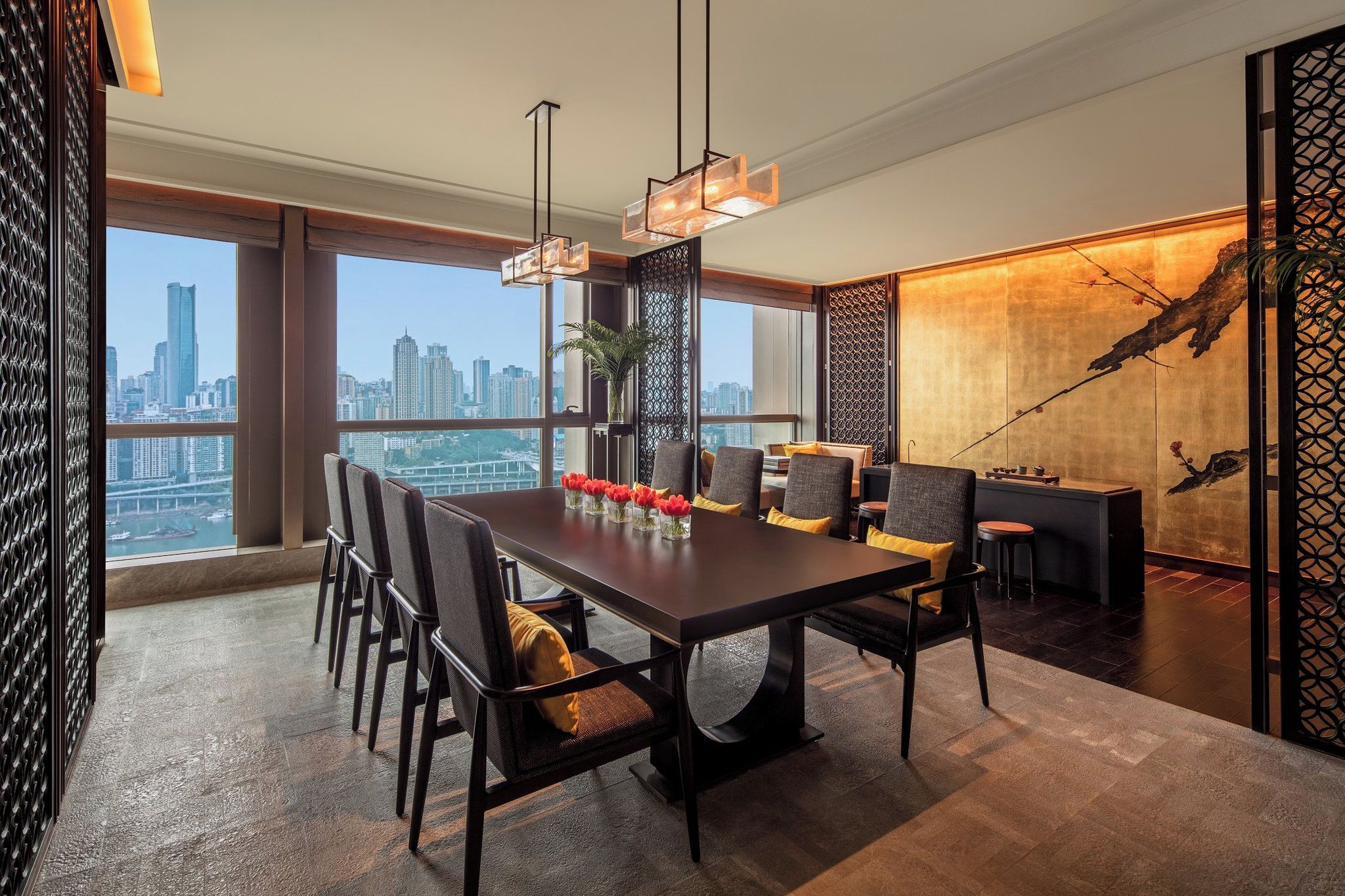 A modern dining area with a city view, a large table, and contemporary chairs.