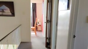 Ein Korridor mit Metallgeländer, einer Tür und einem Gemälde an der Wand.
