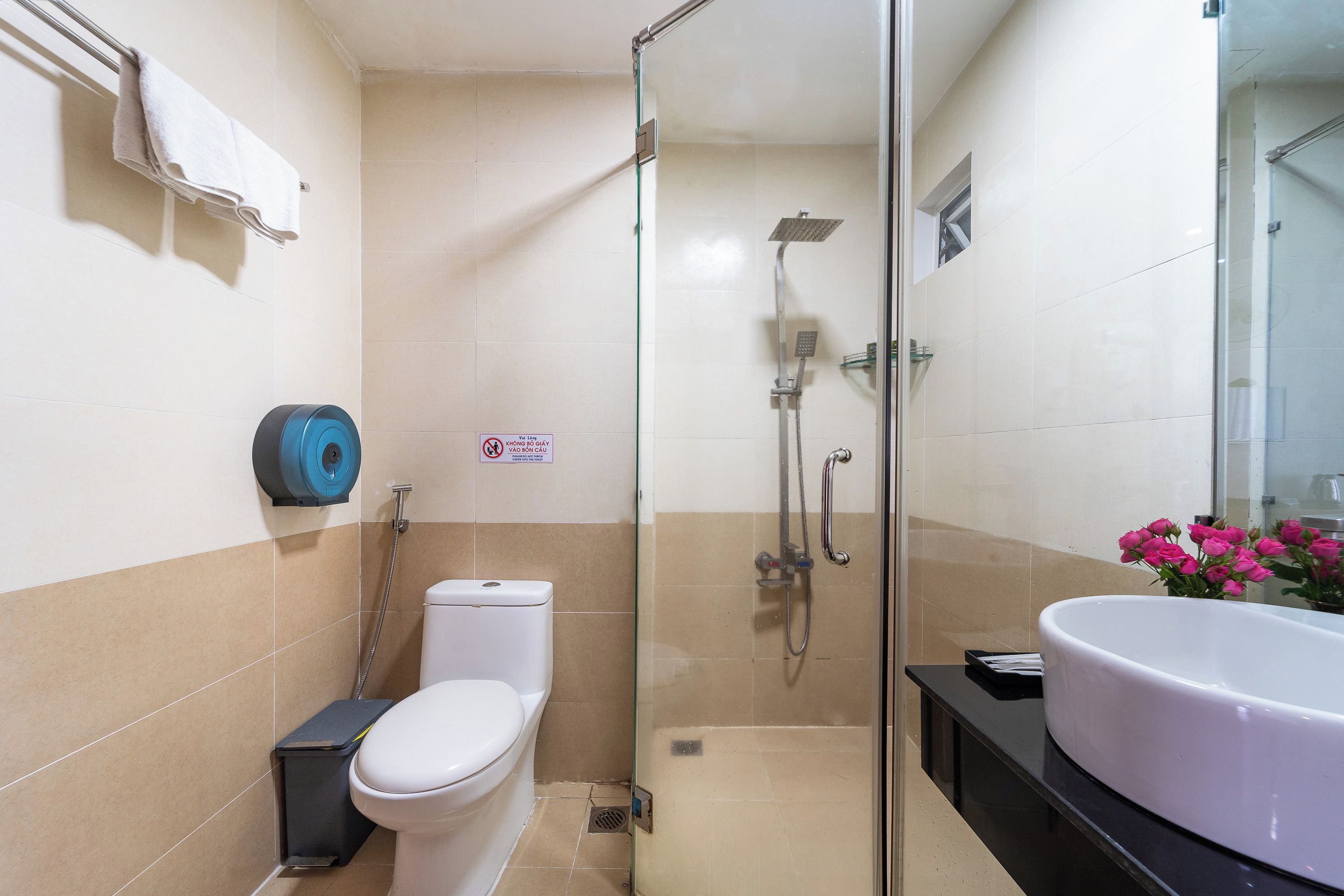 Une salle de bain avec des toilettes, une douche et un lavabo.