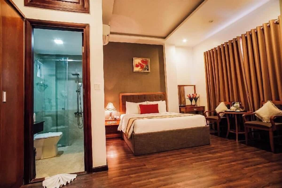 Une chambre d’hôtel équipée d’un lit, d’une table de chevet, d’une lampe et d’un espace douche.