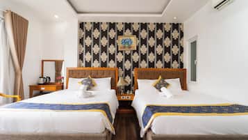 Habitación de hotel con dos camas, una mesita de noche, una lámpara y un cuadro en la pared.
