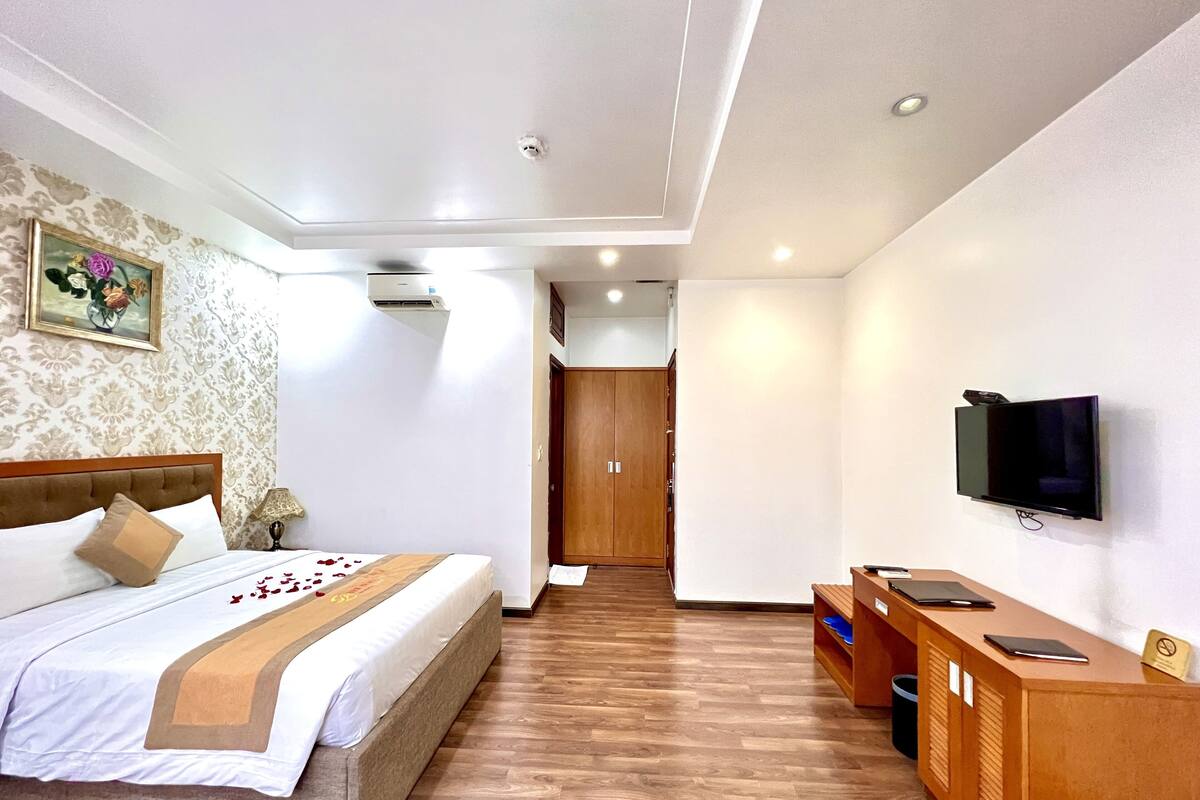 Une chambre d’hôtel équipée d’un lit, d’un bureau, d’une télévision et d’un appareil de climatisation.