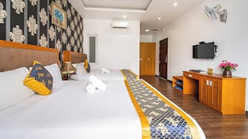 Habitación de hotel con una cama grande, un escritorio, un televisor y un armario.