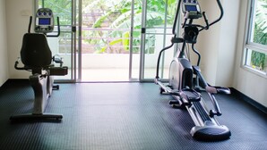 A gym with exercise equipment and large windows. - Laidback Place Apartment (Bangkok)