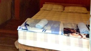 Una habitación con cama, mosquitero colgante y una puerta con una toalla.