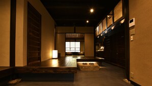 A hallway with wooden flooring, a stone bench, and a traditional Japanese sliding door. - Kuraya Kamigojo-cho (Kyoto)