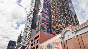 A high-rise building with multiple floors, some with visible balconies and others under construction.
