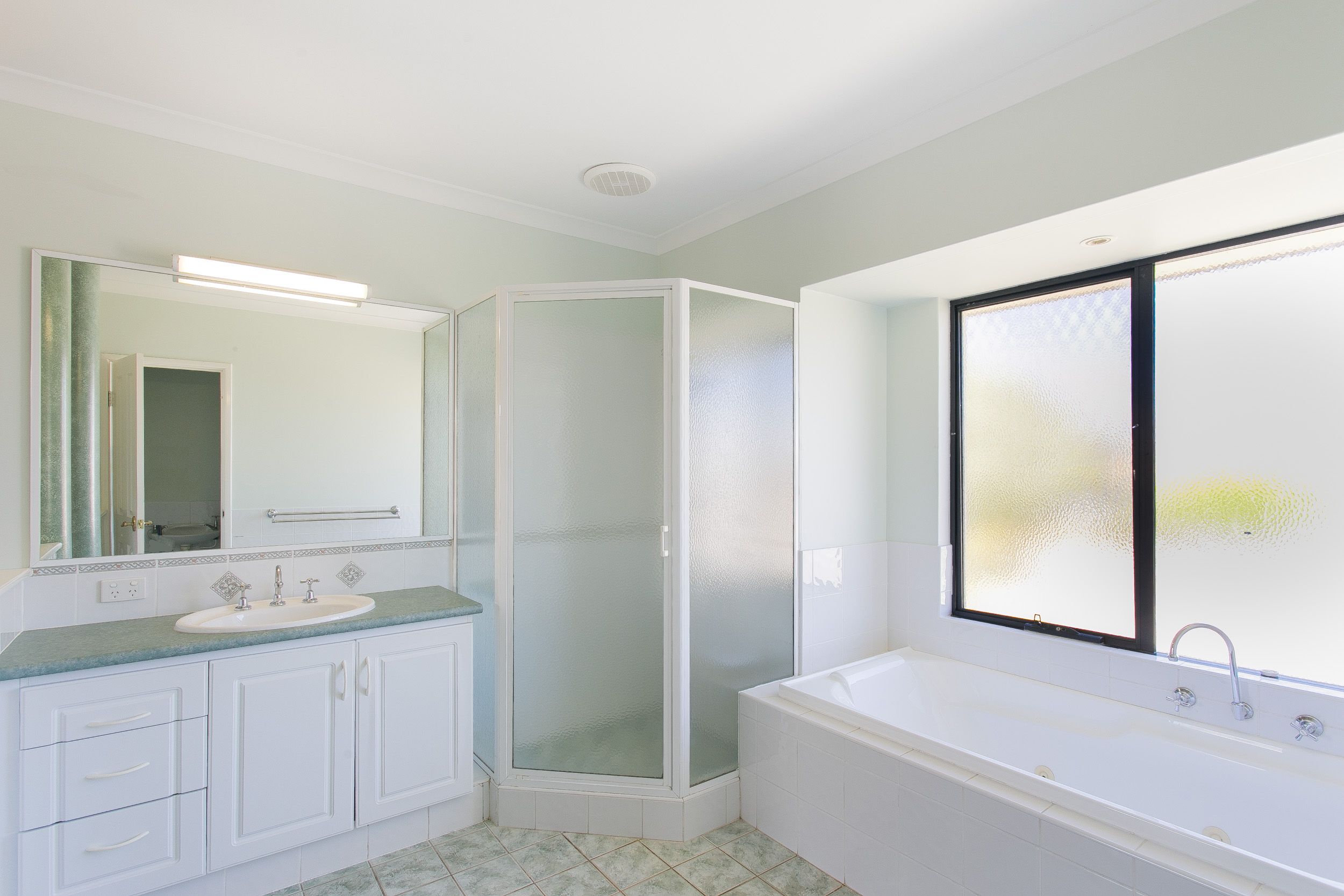 A modern bathroom with a shower, sink, and bathtub.