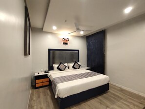 A modern bedroom with a bed, bedside table, and a ceiling fan.
