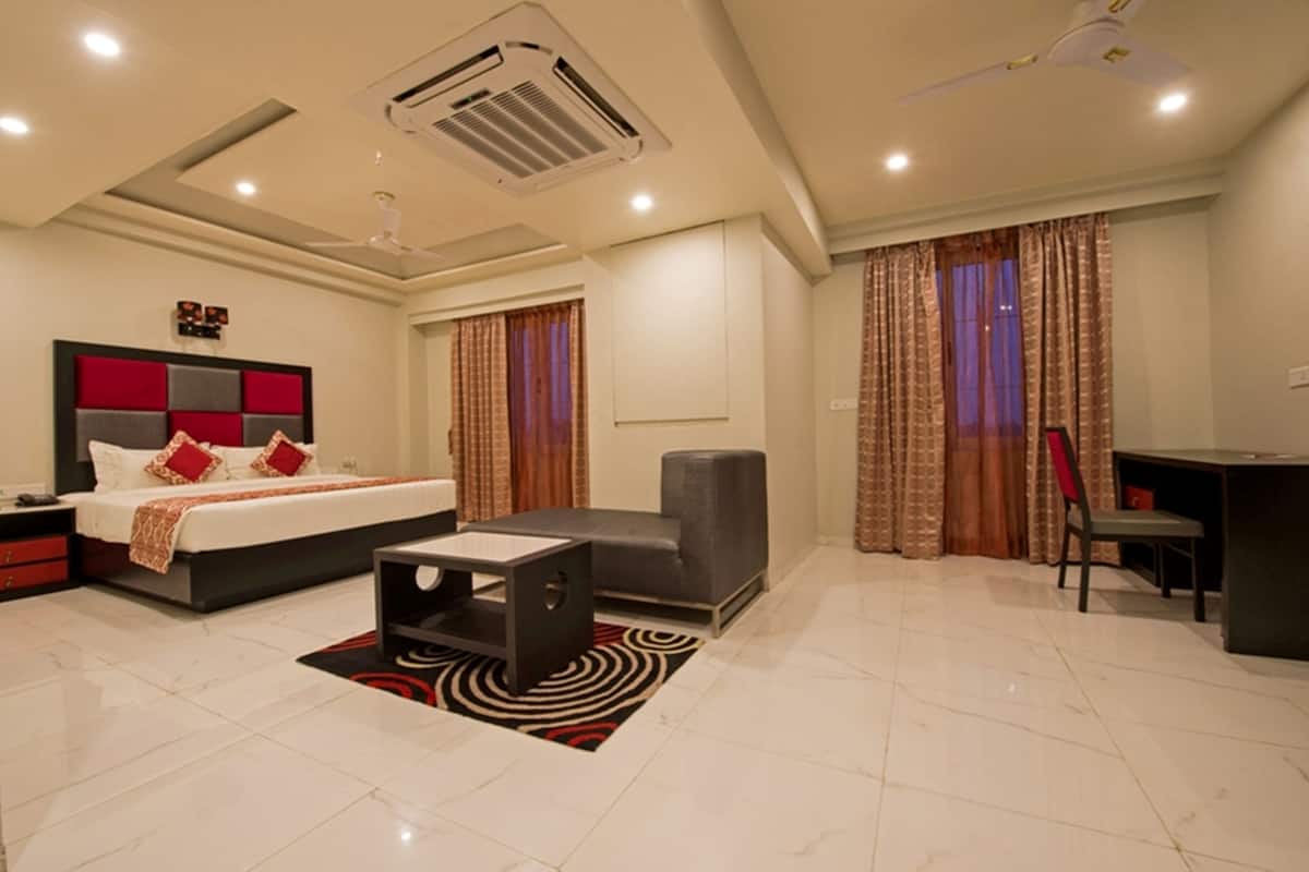 Una habitación de hotel moderna con una cama grande, un escritorio y una zona de estar.
