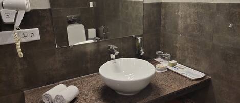 Un baño con lavamanos blanco, secador de pelo y espejo.