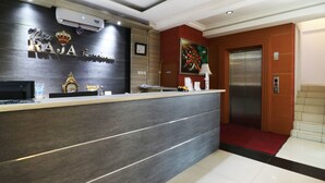 A reception desk with a sign reading "RAJA Residence." - Raja Residence (Jakarta)