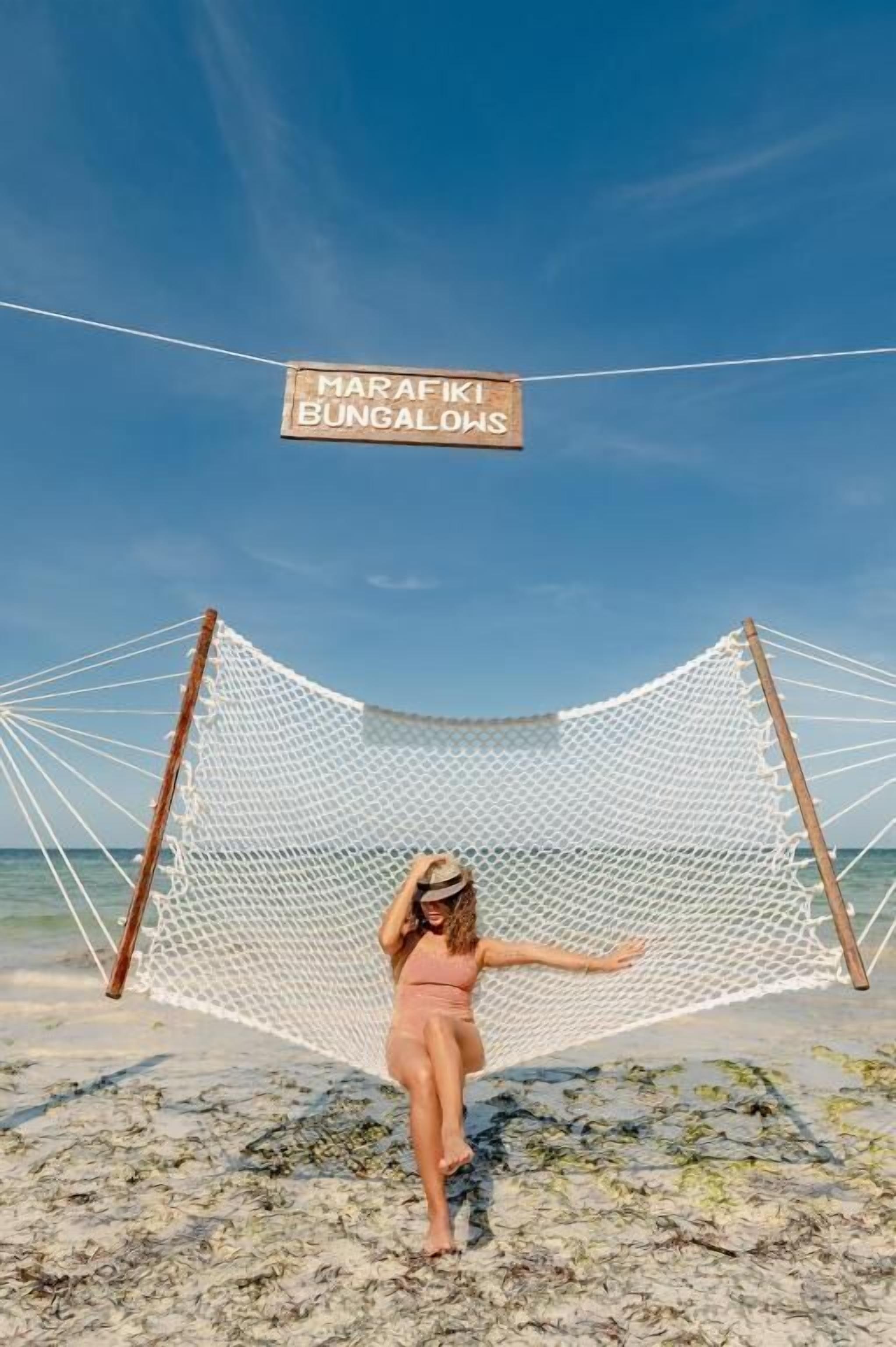 Una hamaca en la playa con un letrero que dice 'MARAFIKI BUNGALOWS'.