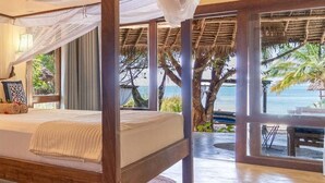 Una habitación con cama con dosel, ventanas amplias y vista al mar.