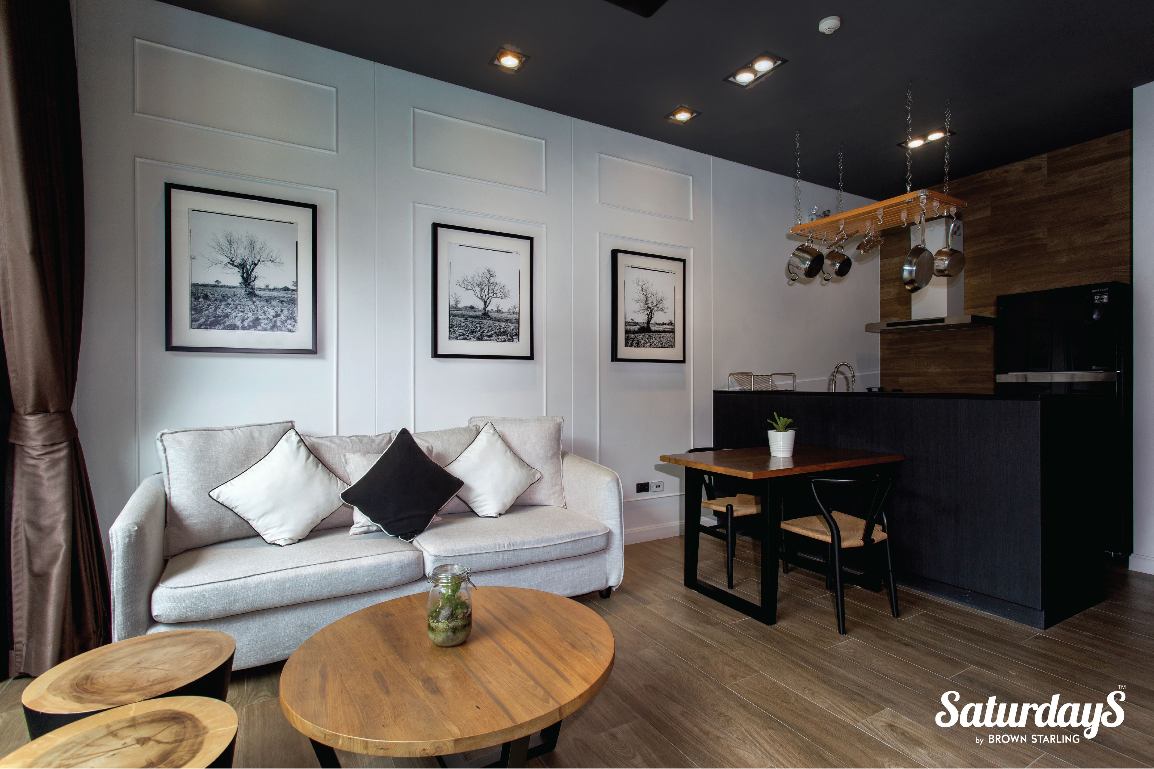 A modern living room with a sofa, coffee table, and framed pictures on the wall.