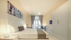 Une chambre d’hôtel moderne équipée d’un grand lit, d’un bureau, d’une armoire et d’un téléviseur.