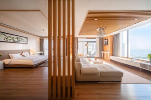 Une chambre d’hôtel moderne dotée d’un grand lit, d’un canapé, d’un coin repas et offrant une vue sur la ville.