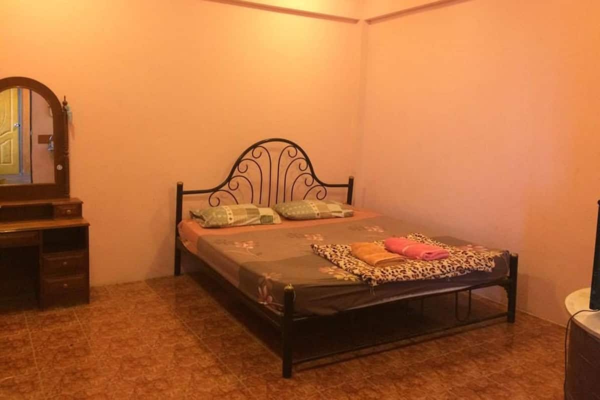 A bedroom with a bed, a dresser, and a mirror.