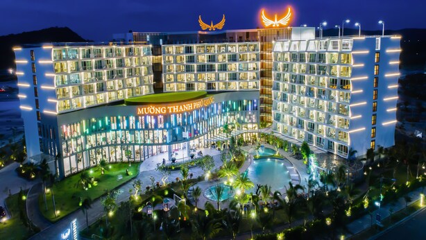 Un hotel de varios pisos con un patio central y una piscina.