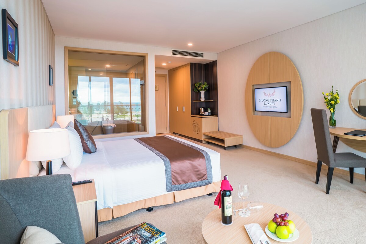 Ein modernes Hotelzimmer mit Bett, Schreibtisch und Sitzgelegenheit.