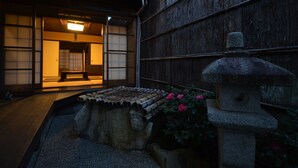 Perinteinen japanilainen huone, jossa on tatamimatto, matala puupöytä ja kivilyhty.