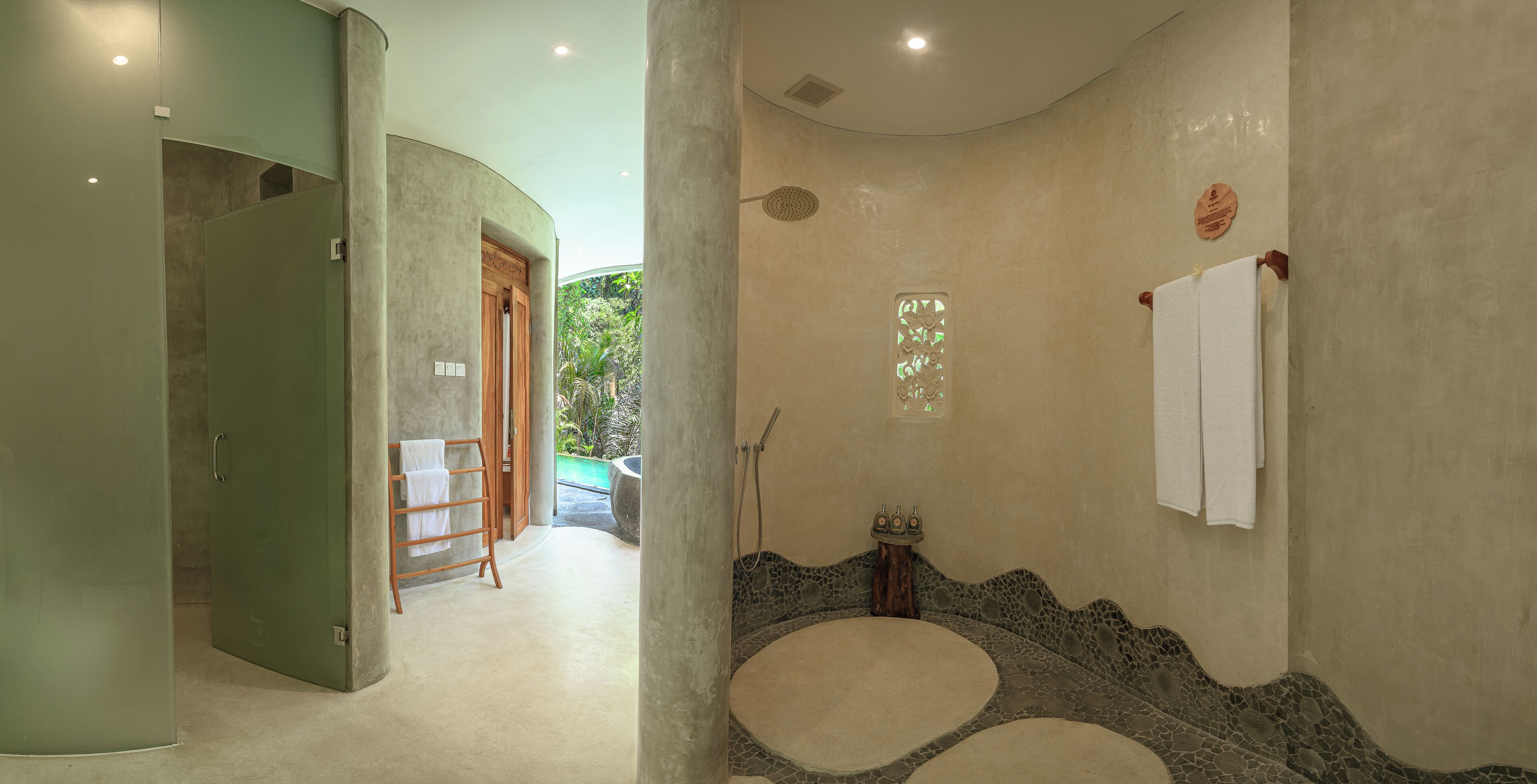 A bathroom with a stone sink, a shower, and a towel rack.
