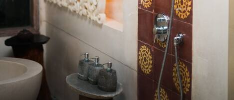 A bathroom with a shower, a sink, and decorative tiles.