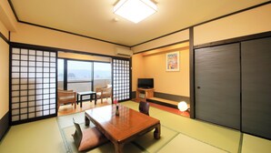 A traditional Japanese room with tatami flooring, a low table, chairs, a TV, and sliding doors. - Yutorelo Yamaga (Yamaga)