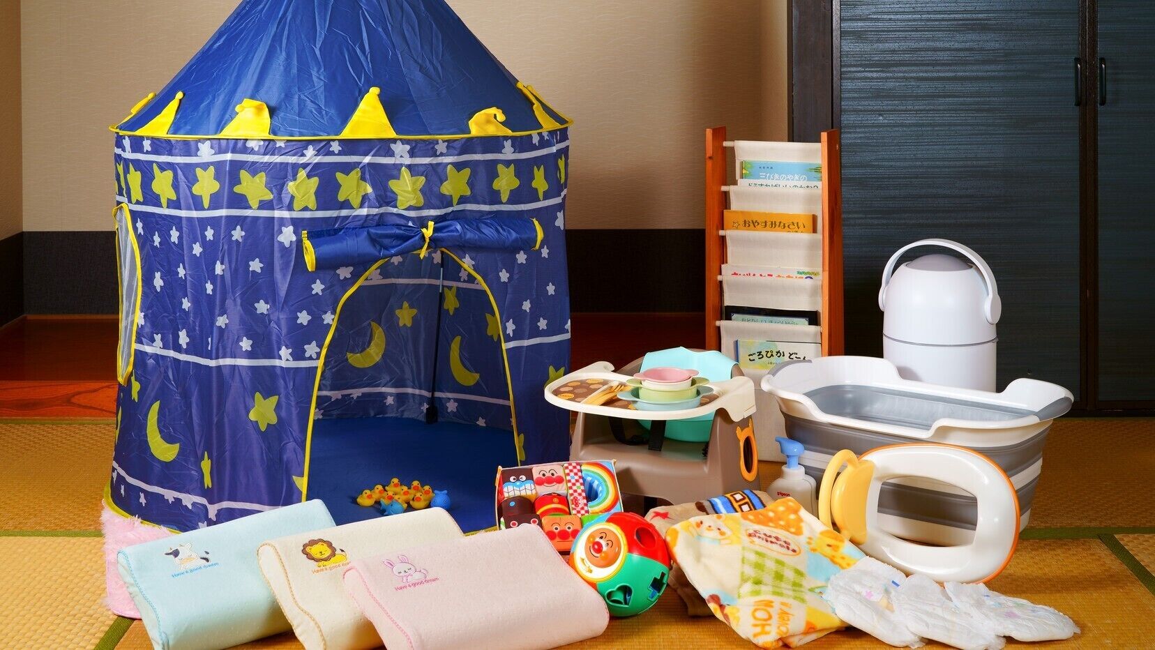 A play tent, a changing table, a baby bathtub, and various toys.