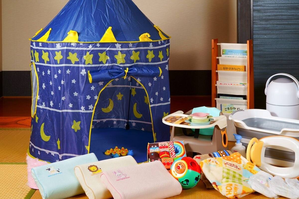 A play tent, a changing table, a baby bathtub, and various toys.