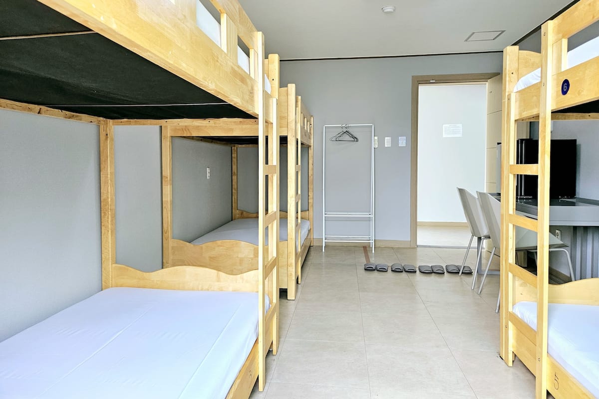 Un dormitorio con literas, un escritorio y una silla.