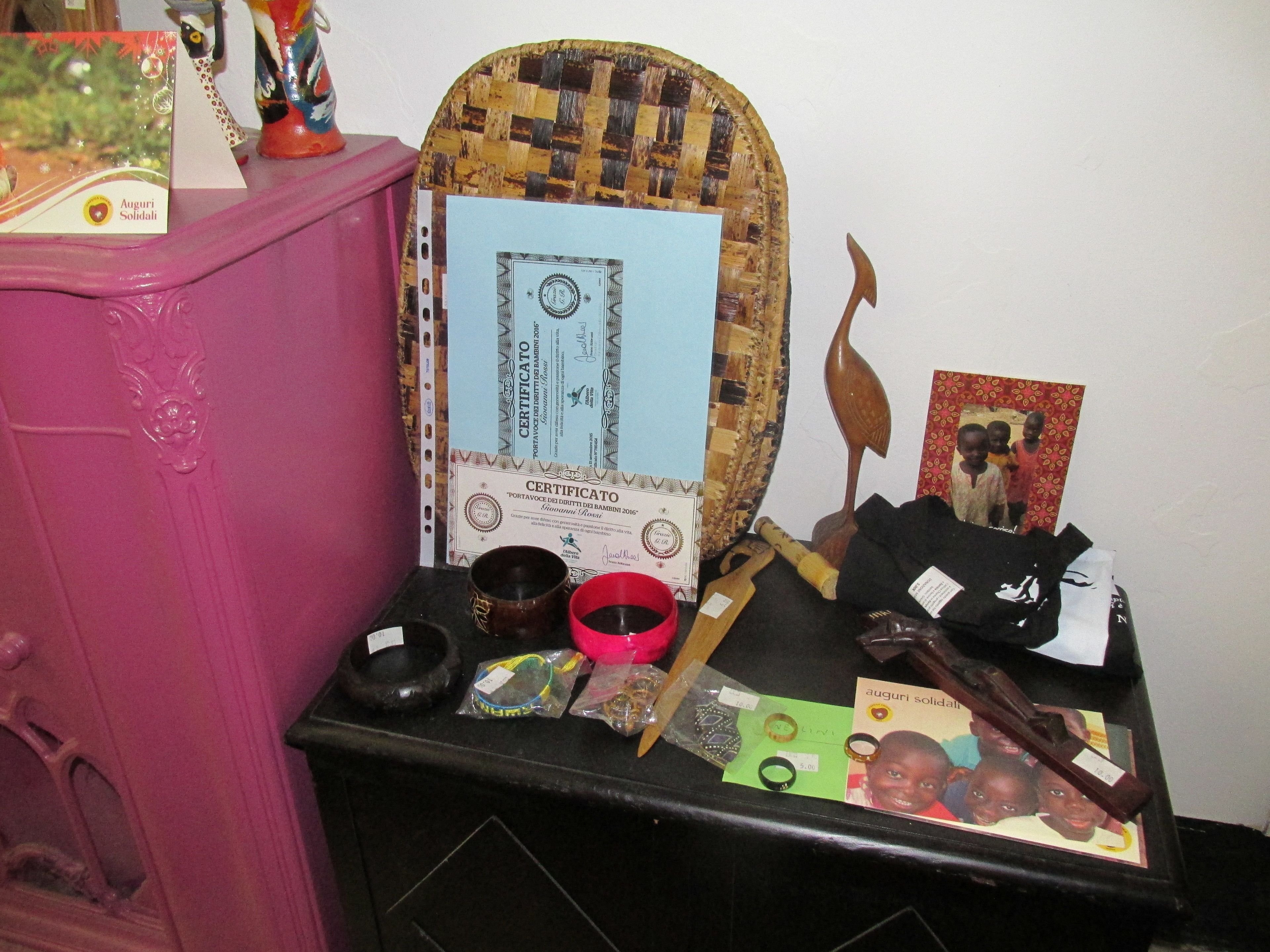 A table with various items including a certificate, a woven basket, a wooden spoon, and some bags.