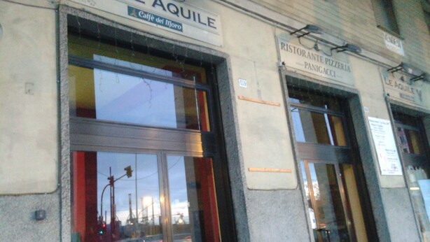 Rakennuksen julkisivussa on kyltit, joissa lukee ’LE AQUILE’ ja ’Caffè del Moro’.