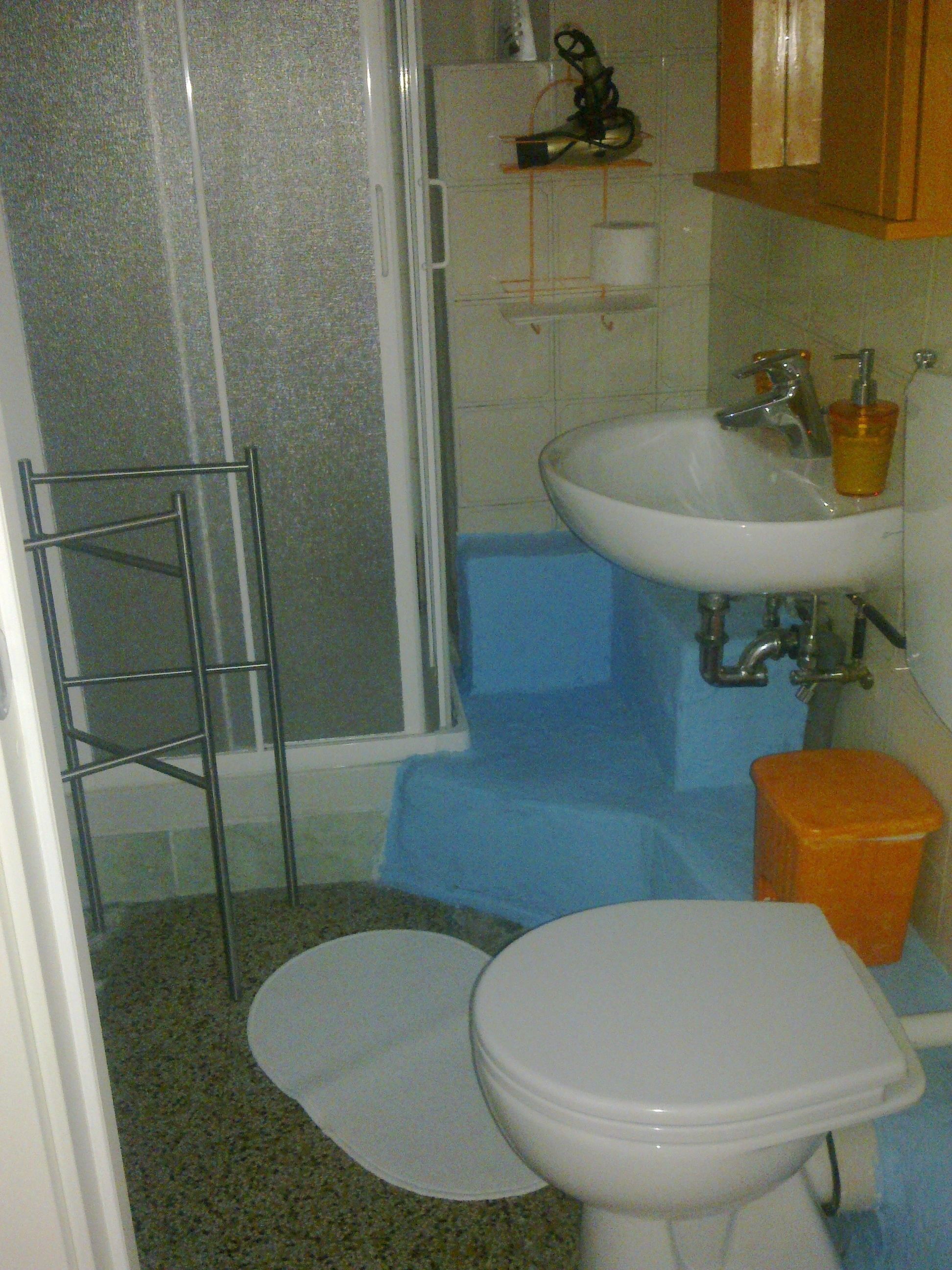 Une salle de bain avec une douche, un lavabo et des toilettes.