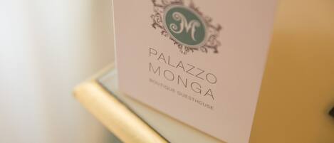 A sign with the text "PALAZZO MONGA BOUTIQUE GUESTHOUSE".