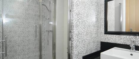 A bathroom with a shower, toilet, and sink.